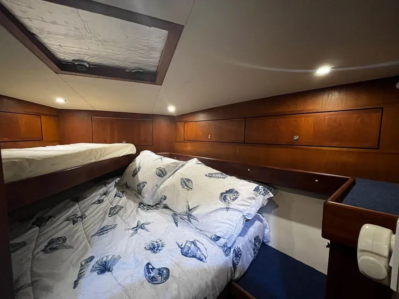 Slide: The Image of Cozy cabin interior of 2005 Mirage Yachts 40 Convertible with wooden paneling and nautical bedding. - 35