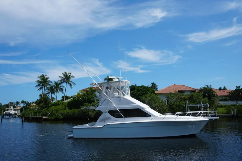 Slide: The Image of 2005 Mirage Yachts 40 Convertible cruising on a scenic waterway with palm trees and blue sky. - 6
