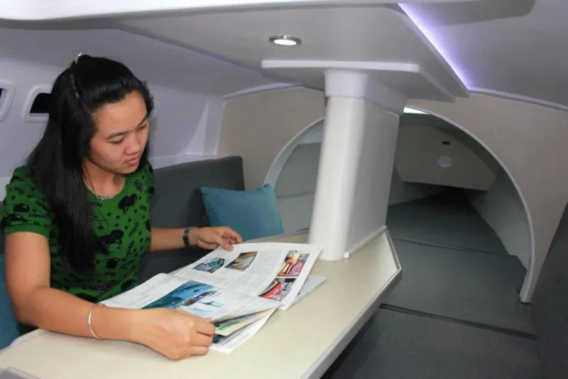 Slide: The Image of Woman reading magazine inside 2022 Corsair 760 boat cabin. - 3