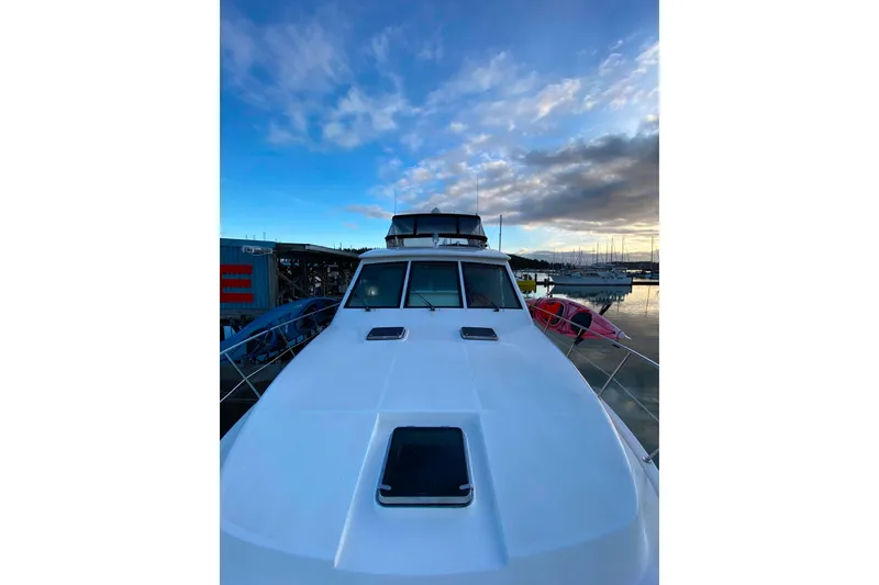 Slide: The Image of Compass 55 boat from 2000 docked at marina under a vibrant sky. - 106