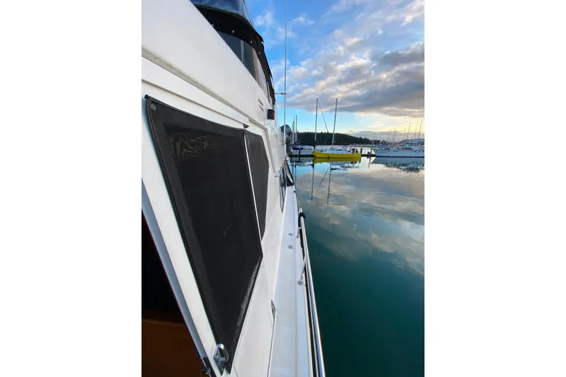 Slide: The Image of Side view of a 2000 Compass 55 yacht docked in a serene marina. - 107