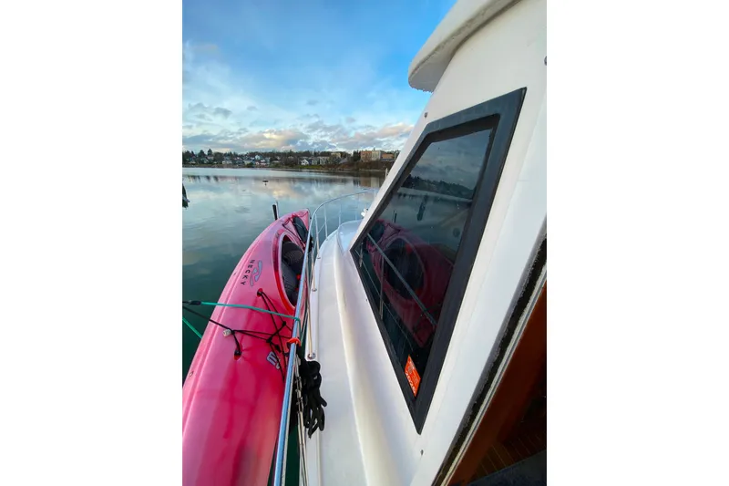Slide: The Image of Boat with pink kayak on deck, calm waters, Compass 55 model, year 2000. - 108