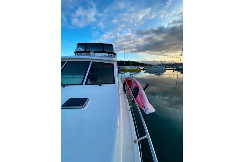 Slide: The Image of Compass 55 boat docked at sunset, reflecting on calm water, 2000 model. - 110