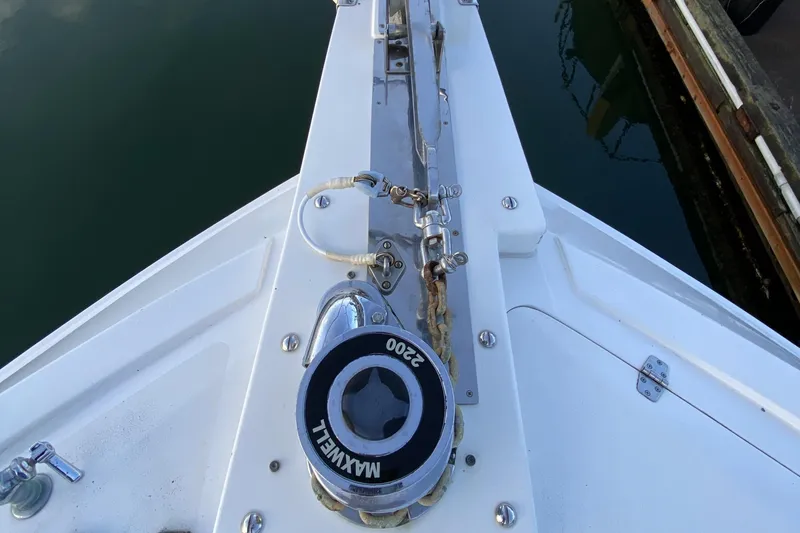 Slide: The Image of Bow of Compass 55 boat, featuring Maxwell winch, docked by the water. - 112