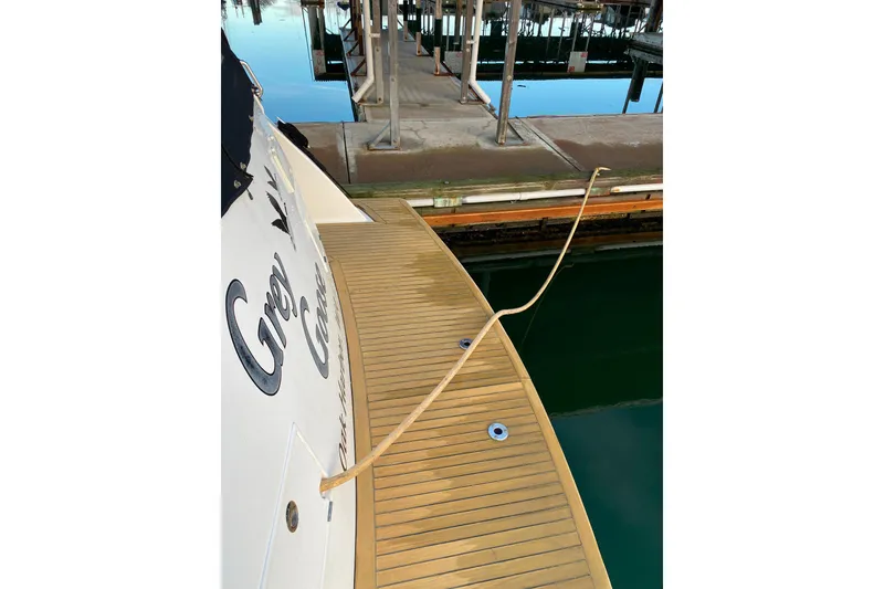 Slide: The Image of Compass 55 yacht docked, showcasing wooden deck and mooring line, year 2000 model. - 114