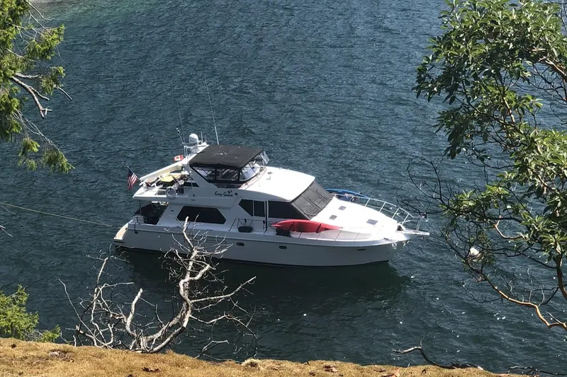 Slide: The Image of Compass 55 yacht from 2000 anchored in a scenic, tree-lined waterway. - 117