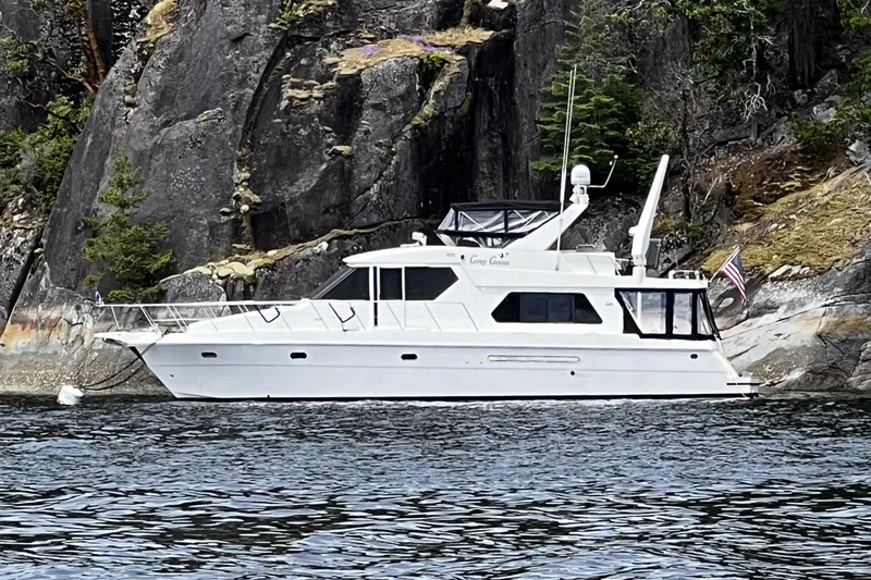Slide: The Image of White Compass 55 yacht from 2000 moored near rocky shoreline. - 119