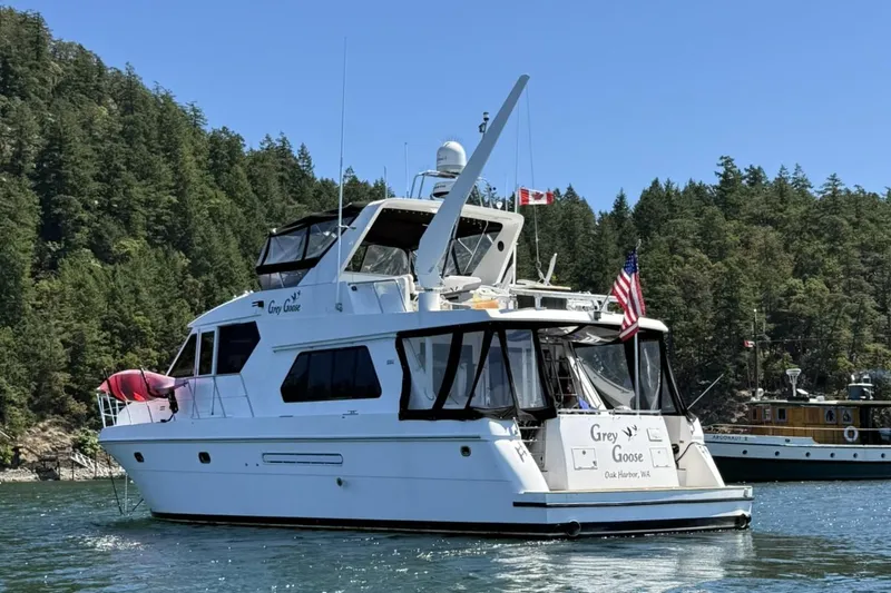 Slide: The Image of Compass 55 yacht from 2000, named "Grey Goose," on water with forested background. - 121