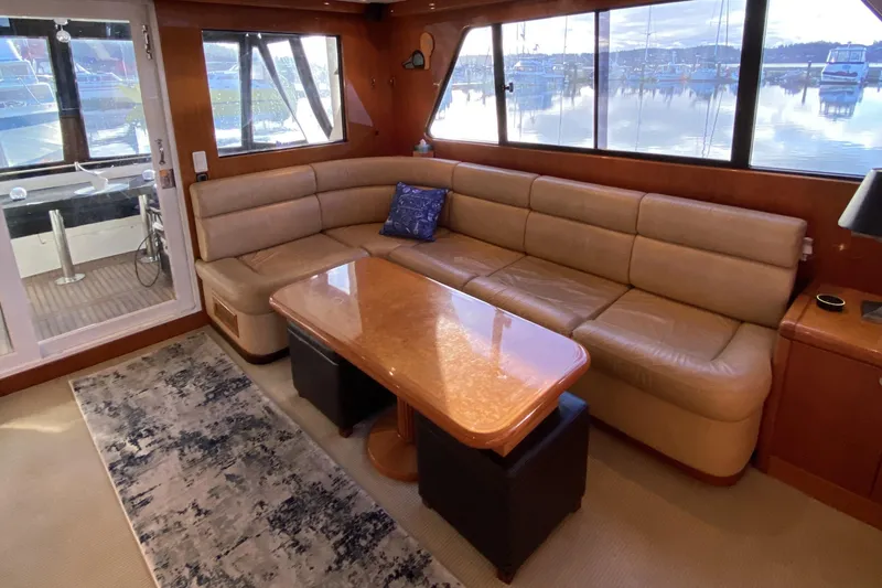 Slide: The Image of Luxurious interior of 2000 Compass 55 yacht with leather seating and wooden table. - 13