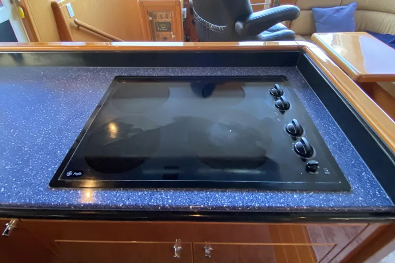 Slide: The Image of Sleek black cooktop on Compass 55 yacht, 2000 model, with modern control knobs. - 29