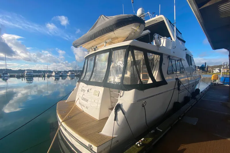 Slide: The Image of Compass 55 yacht docked at marina, clear sky, calm water, 2000 model. - 4