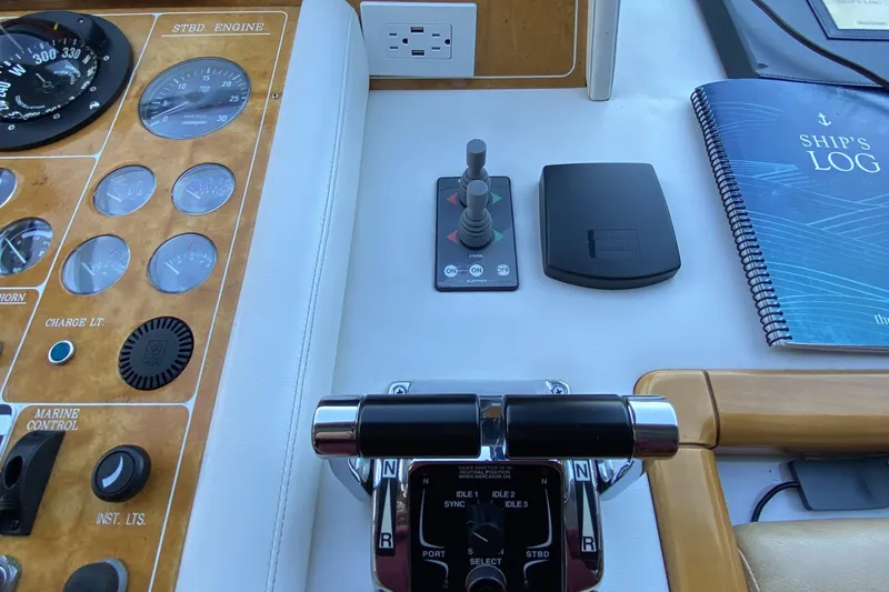 Slide: The Image of Boat control panel with gauges, levers, and ship's log book, Compass 55, year 2000. - 44