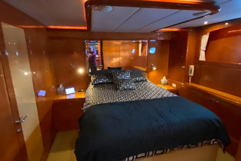 Slide: The Image of Luxurious bedroom interior on a 2000 Compass 55 yacht, featuring elegant wood paneling. - 58