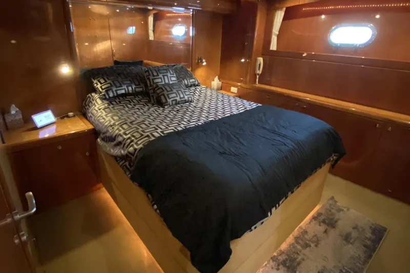 Slide: The Image of Luxurious bedroom interior of a 2000 Compass 55 yacht with elegant wood paneling. - 59
