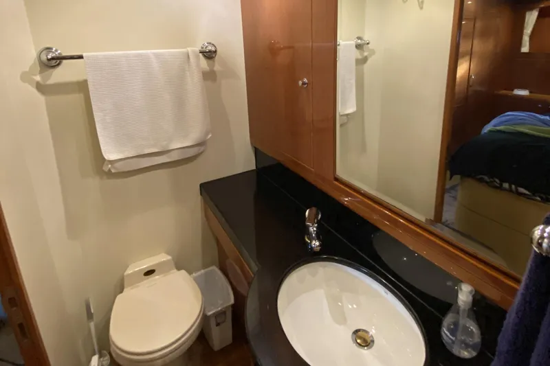 Slide: The Image of Compact bathroom in a 2000 Compass 55 yacht, featuring a sink, toilet, and mirror. - 63
