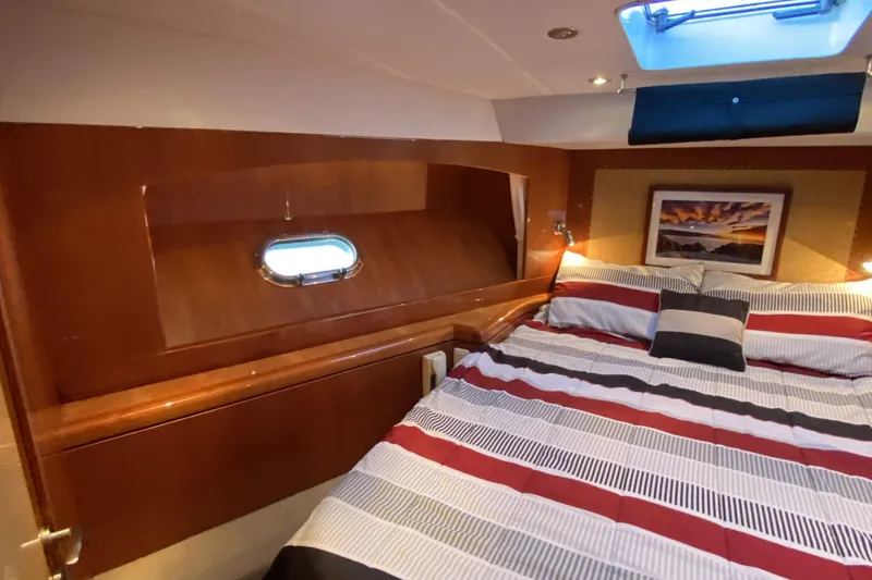 Slide: The Image of Luxurious cabin interior of 2000 Compass 55 yacht with striped bedding and wall art. - 65
