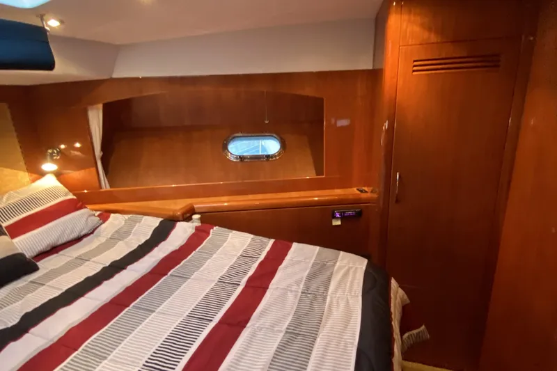 Slide: The Image of Cozy cabin interior of 2000 Compass 55 yacht with striped bedding and wooden finishes. - 66