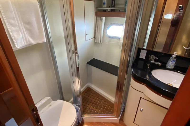 Slide: The Image of Compact yacht bathroom with shower, sink, and toilet in a 2000 Compass 55 model. - 68