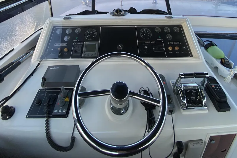 Slide: The Image of Boat control panel of a 2000 Compass 55 with steering wheel and navigation instruments. - 73