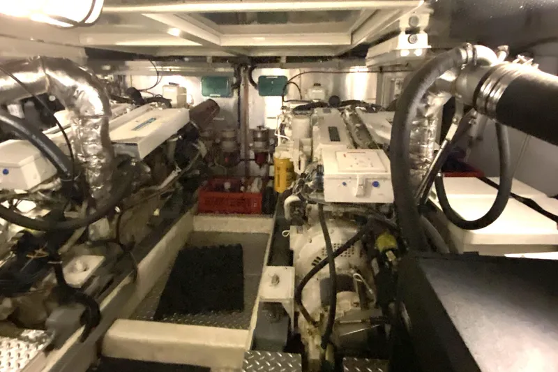 Slide: The Image of Engine room of a 2000 Compass 55 yacht, featuring dual engines and complex piping. - 83