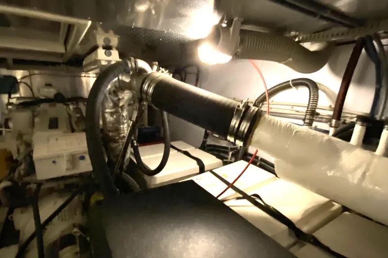 Slide: The Image of Engine room of a 2000 Compass 55 boat with visible pipes and machinery. - 84