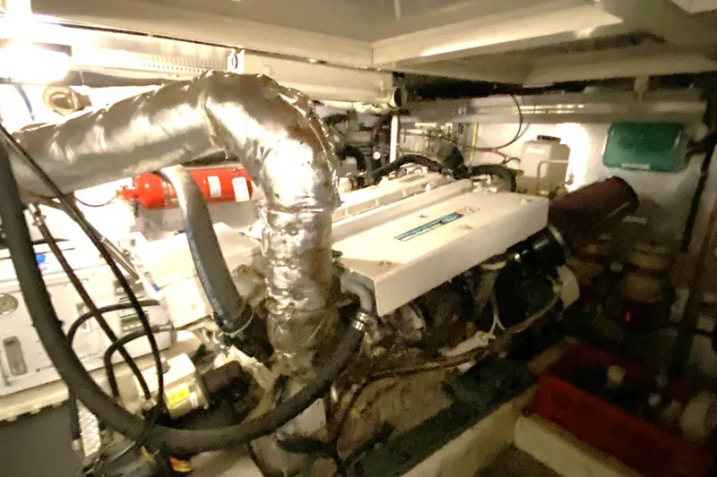Slide: The Image of Engine room of a 2000 Compass 55 boat, featuring complex machinery and piping. - 86