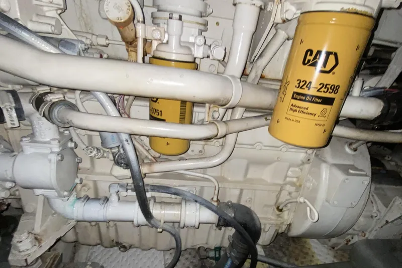 Slide: The Image of Engine compartment of a 2000 Compass 55 with CAT oil filters and visible piping. - 89