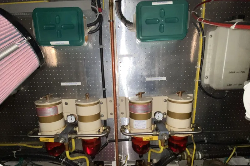 Slide: The Image of Engine room components of a 2000 Compass 55, featuring filters and wiring. - 90