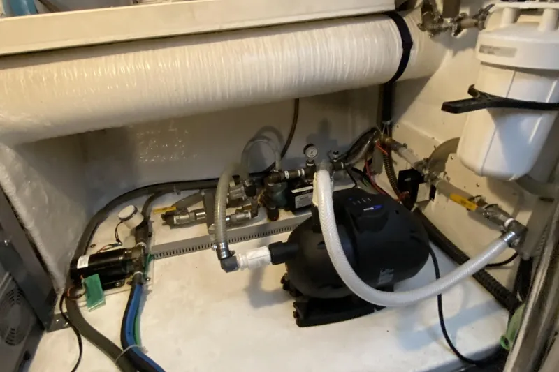 Slide: The Image of Engine room of a 2000 Compass 55 boat with various mechanical components. - 96