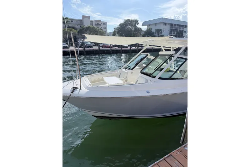 Slide: The Image of 2022 Pursuit DC 266 Dual Console boat docked by the water. - 10