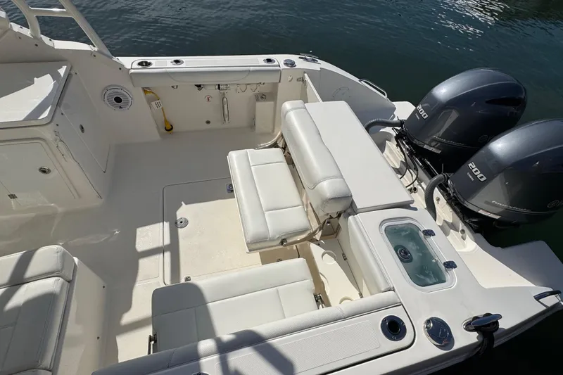 Slide: The Image of 2022 Pursuit DC 266 Dual Console boat interior with seating and twin 200 horsepower engines. - 19