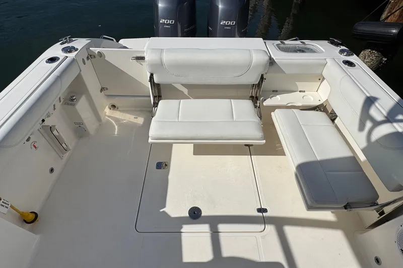Slide: The Image of 2022 Pursuit DC 266 Dual Console boat interior with white seating and twin engines. - 21