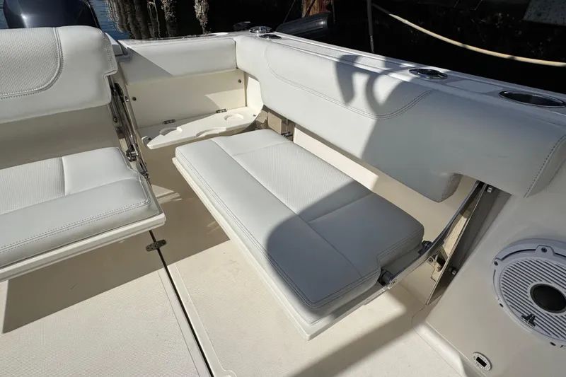 Slide: The Image of 2022 Pursuit DC 266 Dual Console boat interior with white seating and cup holders. - 22