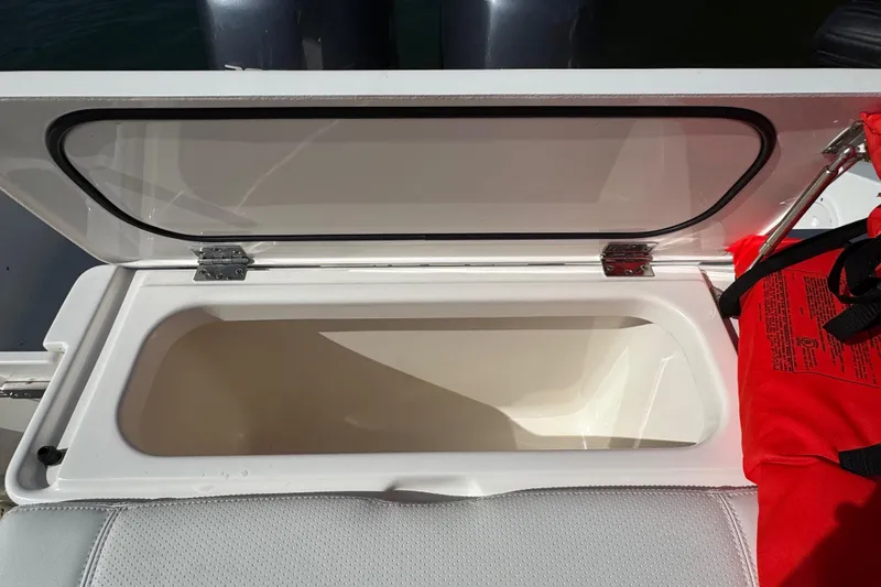 Slide: The Image of Open storage compartment on 2022 Pursuit DC 266 Dual Console boat. - 27