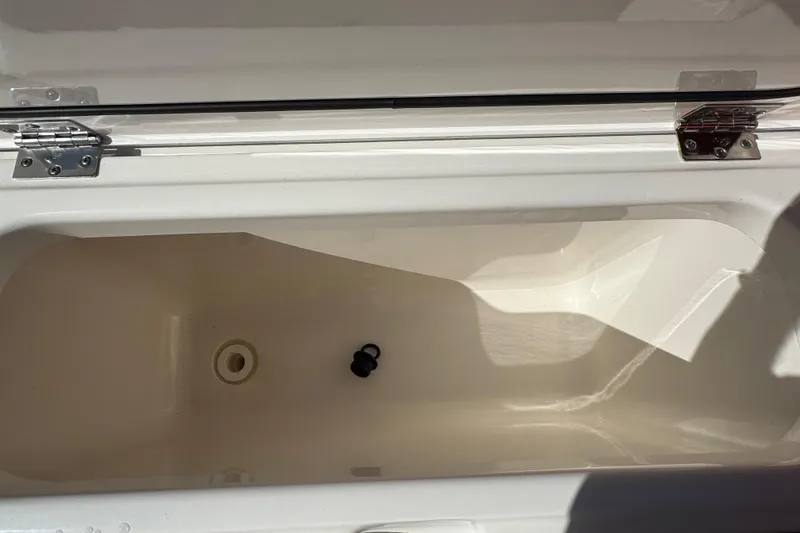 Slide: The Image of Open storage compartment of 2022 Pursuit DC 266 Dual Console boat. - 28