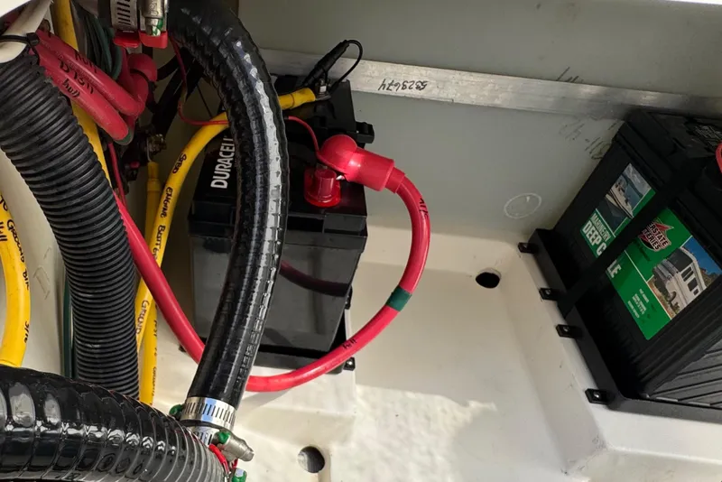 Slide: The Image of Battery compartment of 2022 Pursuit DC 266 Dual Console boat with cables and connections. - 42