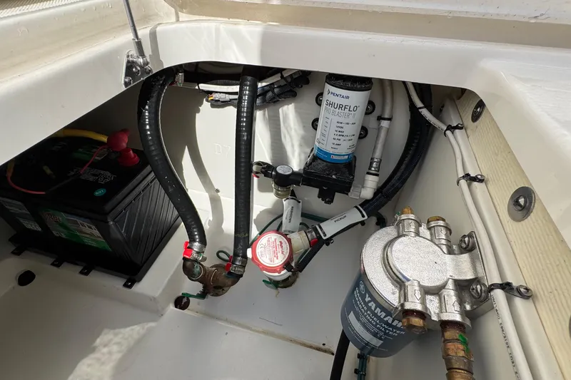 Slide: The Image of 2022 Pursuit DC 266 Dual Console boat compartment with battery and pump system. - 43