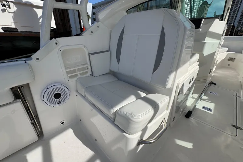 Slide: The Image of 2022 Pursuit DC 266 Dual Console boat interior with white seating and speaker. - 46
