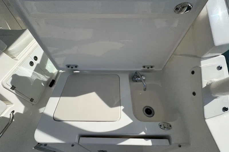 Slide: The Image of 2022 Pursuit DC 266 Dual Console boat sink and storage area. - 49