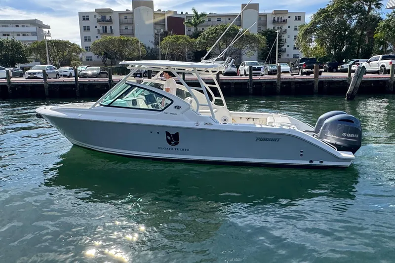 Slide: The Image of 2022 Pursuit DC 266 Dual Console boat on water, with Yamaha engine, near urban waterfront. - 5