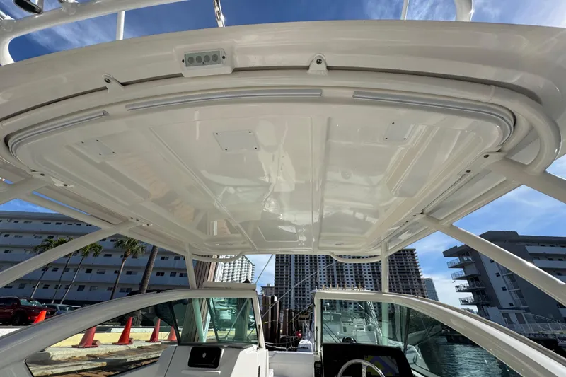 Slide: The Image of 2022 Pursuit DC 266 Dual Console boat interior with hardtop, docked near urban buildings. - 51