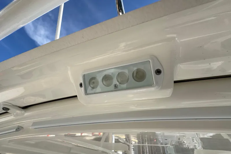 Slide: The Image of LED light fixture on 2022 Pursuit DC 266 Dual Console boat, under clear blue sky. - 52