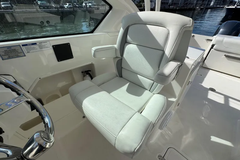 Slide: The Image of Captain's seat on 2022 Pursuit DC 266 Dual Console boat, featuring sleek design and comfort. - 53