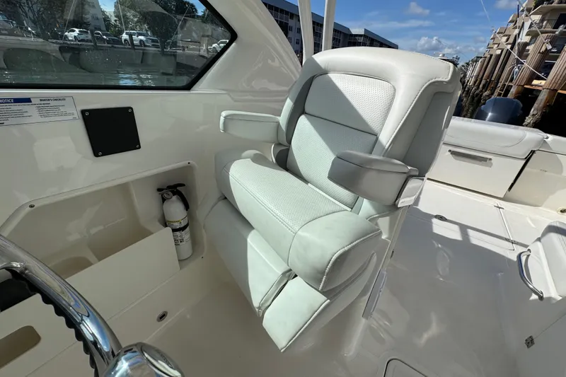 Slide: The Image of 2022 Pursuit DC 266 Dual Console boat interior with plush seating and steering wheel. - 54