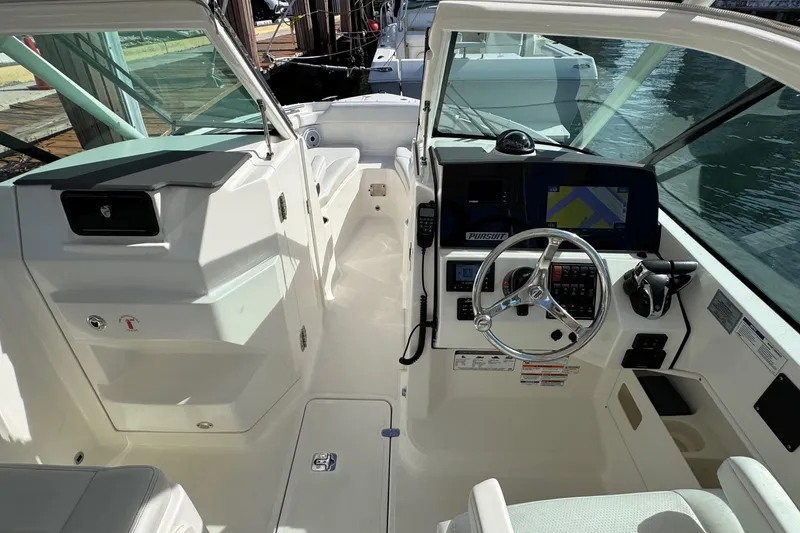 Slide: The Image of 2022 Pursuit DC 266 Dual Console boat interior with steering wheel and navigation system. - 57