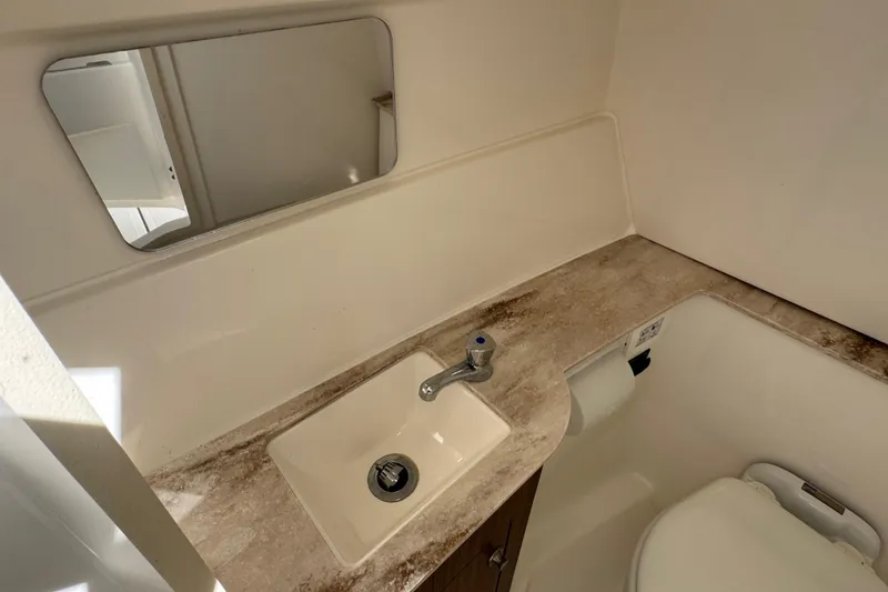 Slide: The Image of 2022 Pursuit DC 266 Dual Console boat bathroom with sink and mirror. - 68