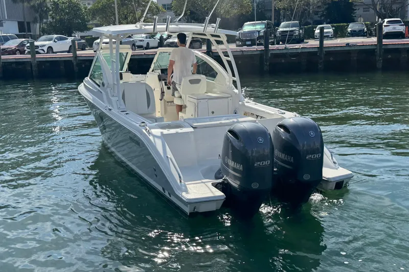 Slide: The Image of 2022 Pursuit DC 266 Dual Console boat with twin Yamaha 200 engines on water. - 7