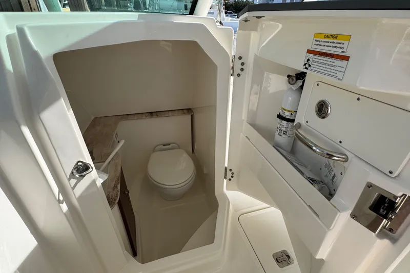 Slide: The Image of 2022 Pursuit DC 266 Dual Console boat interior with compact marine toilet. - 70