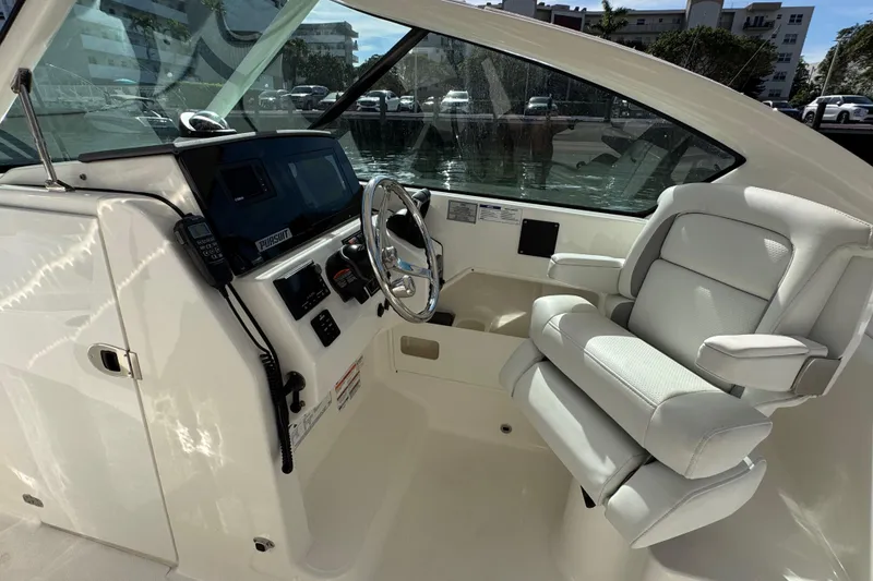 Slide: The Image of 2022 Pursuit DC 266 Dual Console boat interior with steering wheel and captain's chair. - 72