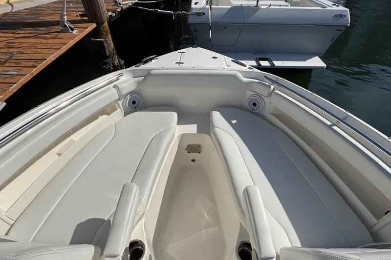 Slide: The Image of 2022 Pursuit DC 266 Dual Console boat interior with white seating and cup holders. - 75